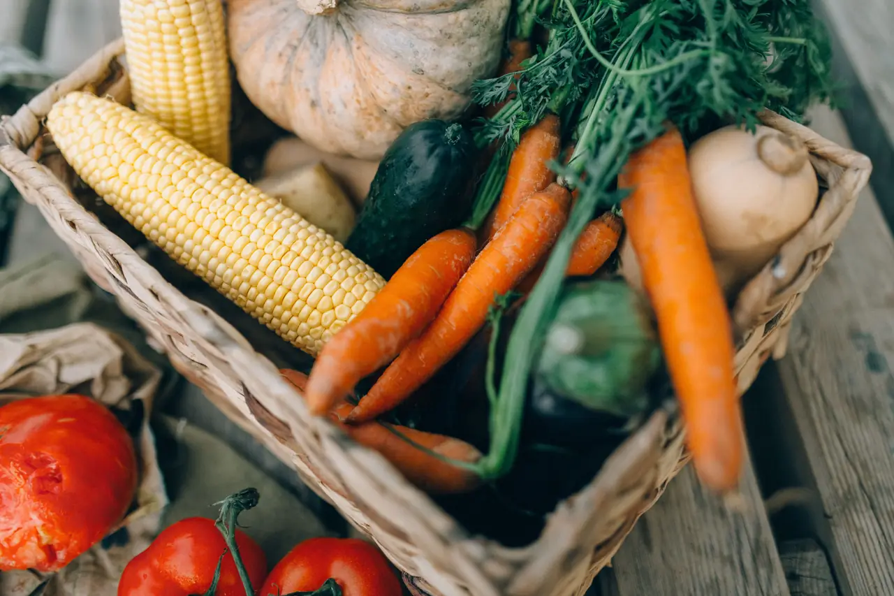 A basket of fresh vegetables and maize